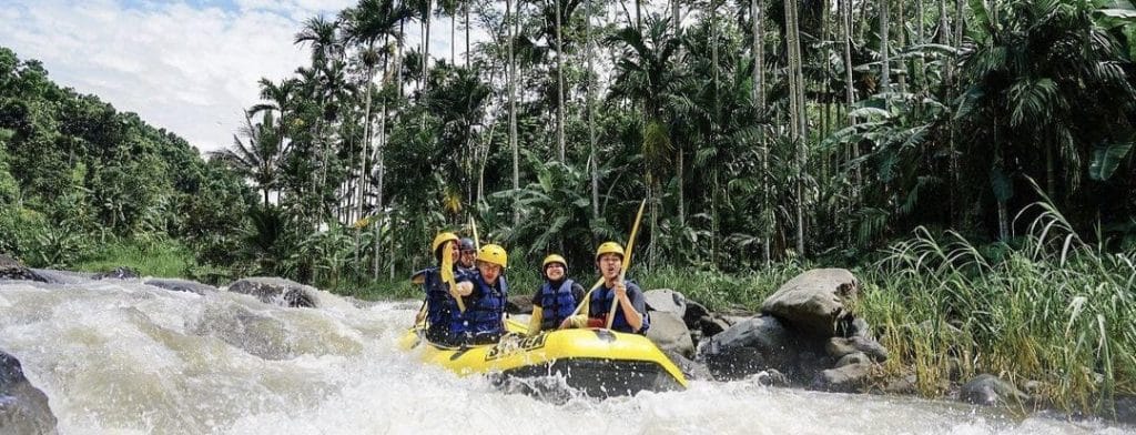 Peserta arung jeram menikmati perjalanan menyusuri sungai di Songa Bawah, dengan suasana alam yang asri dan damai.